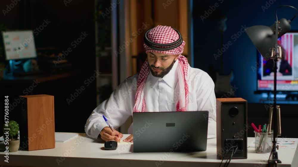 Man at home paying attention in elearning seminar teleconference with teacher, writing memo to remember later. Homeschooling student listening to lesson while taking note of weekend homework Man at home paying attention in elearning seminar teleconference with teacher, writing memo to remember later. Homeschooling student listening to lesson while taking note of weekend homework