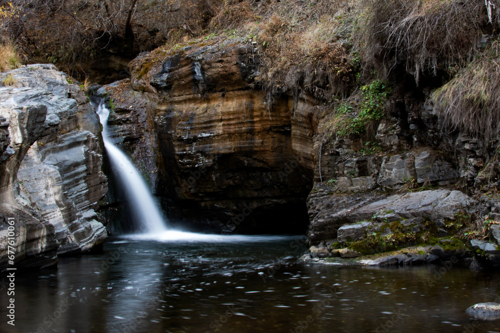 Naklejka premium A small waterfall in the middle of the forest. natural pool and waterfall. River and rocks