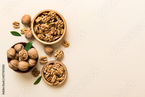 Walnut kernel halves, in a wooden bowl. Close-up, from above on colored background. Healthy eating Walnut concept. Super foods with copy space