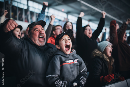 Excited parents and kids celebrating the victory of their team. Sports fans chanting and cheering for their ice hockey team. Family with children watching hockey match. photo