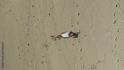 Aerial view of a woman relaxing on the beach along the shoreline in Ilot Lievres, Trou d'Eau Douce, Flacq districit, Mauritius. photo