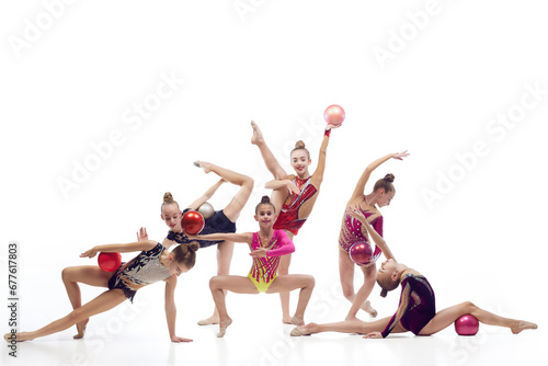 Flexible, artistic, talented children, girls, rhythmic gymnasts dancing with ball against white studio background. Concept of choreography, hobby and art, sport, childhood, performance