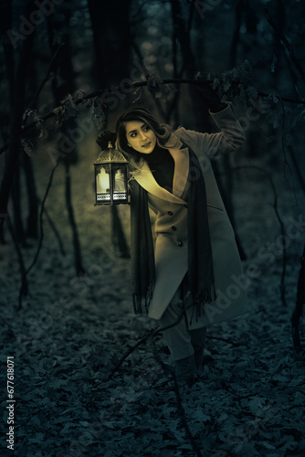 Woman with a lantern in the forest at night