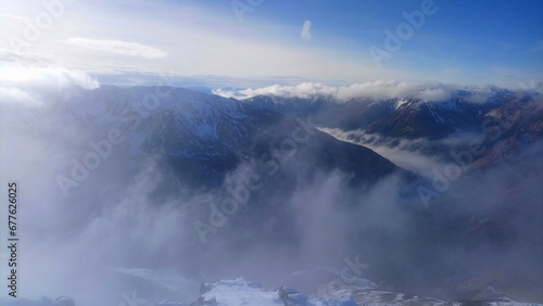 Fototapeta Naklejka Na Ścianę i Meble -  Clouds enshroud the alpine majesty of Kasprowy Wierch, with snow-clad peaks piercing the mist for a tranquil landscape; summits stand majestic above rolling valley clouds.