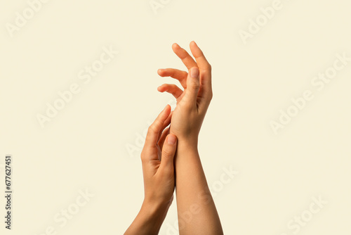 Close Up image of gentle female hands, healthy skin isolated on beige background
