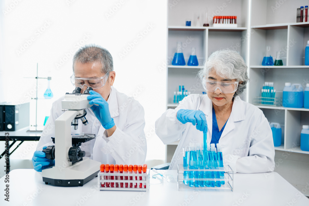 scientists conducting research investigations in a medical laboratory, a researcher in the foreground is using a microscope in laboratory for medicine. .. scientists conducting research investigations in a medical laboratory, a researcher in the foreground is using a microscope in laboratory for medicine. ..