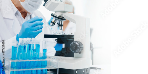 scientists conducting research investigations in a medical laboratory, a researcher in the foreground is using a microscope in laboratory for medicine. ..
