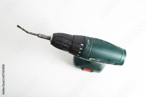 Broken low-quality drill in a screwdriver on a white background, industry photo