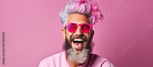 The young hipster model with vibrant pink hair and a stylish fashion sense had a happy smile on his face as he embraced his unique background and expressed his fun and colorful lifestyle th photo