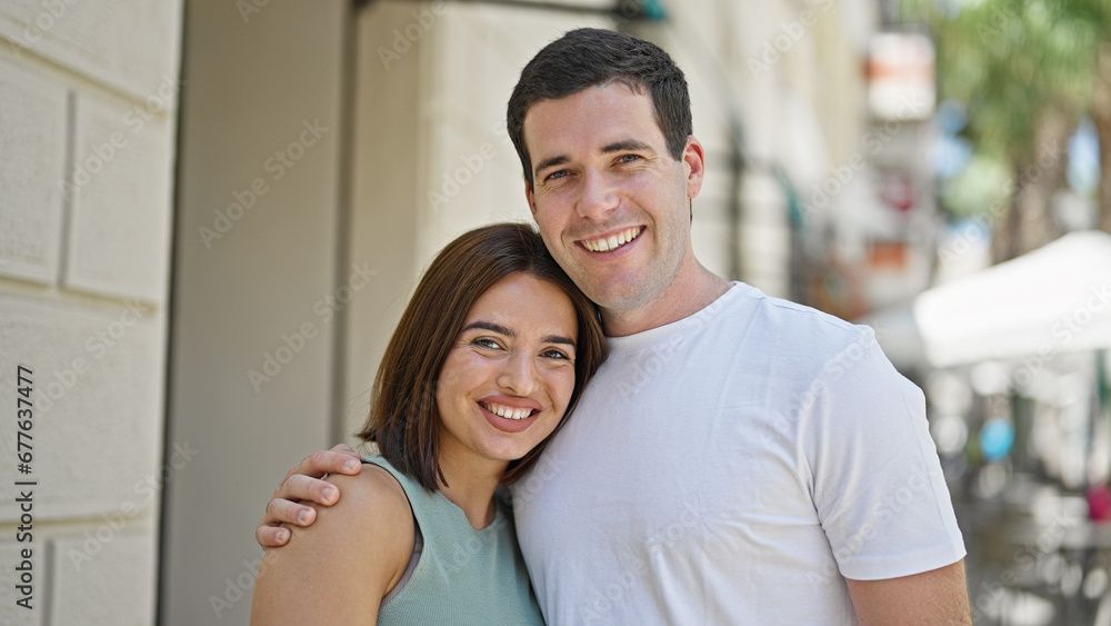 Beautiful couple smiling confident hugging each other at street