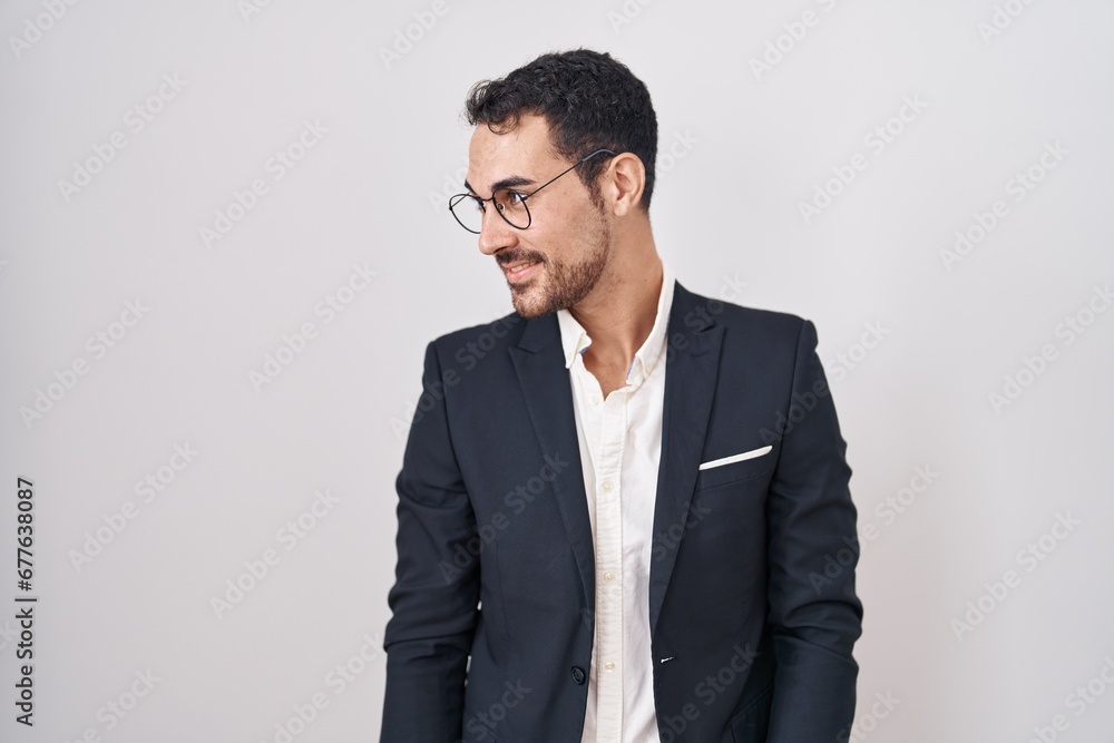 Handsome business hispanic man standing over white background looking away to side with smile on face, natural expression. laughing confident. Handsome business hispanic man standing over white background looking away to side with smile on face, natural expression. laughing confident.