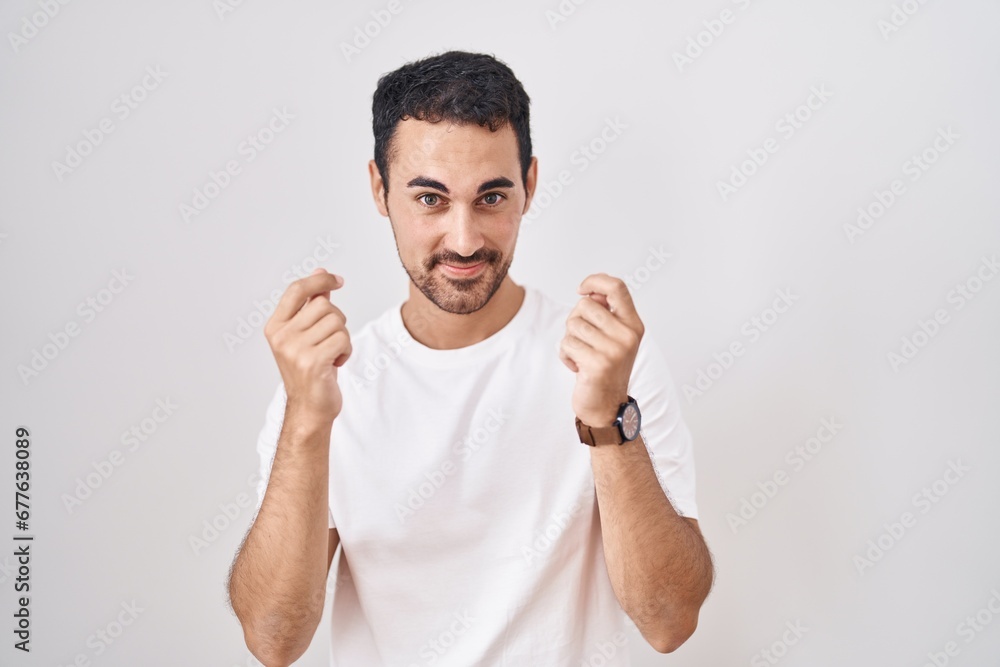 Handsome hispanic man standing over white background doing money gesture with hands, asking for salary payment, millionaire business Handsome hispanic man standing over white background doing money gesture with hands, asking for salary payment, millionaire business