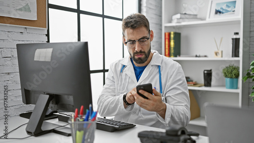 Bild auf Leinwand Handsome young hispanic man working as a doctor, engrossed in online consultatio