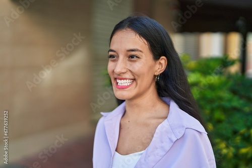 Young beautiful hispanic woman smiling confident looking to the side at street © Krakenimages.com
