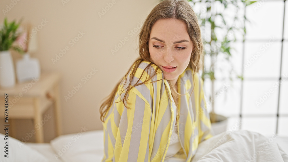 Young blonde woman sitting on bed with relaxed expression at bedroom Young blonde woman sitting on bed with relaxed expression at bedroom