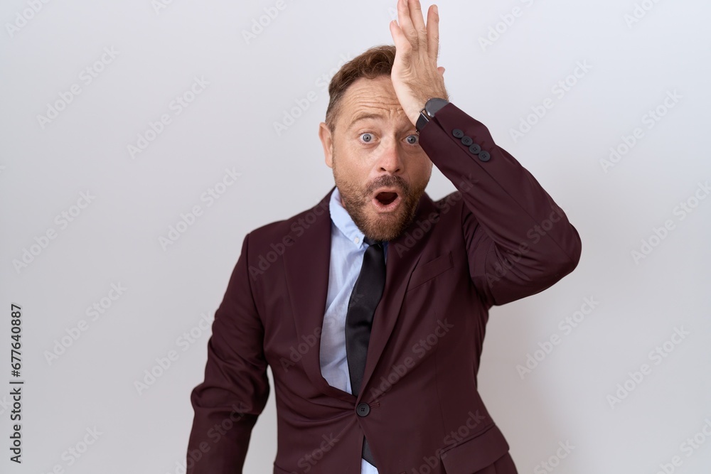 Middle age business man with beard wearing suit and tie surprised with hand on head for mistake, remember error. forgot, bad memory concept. Middle age business man with beard wearing suit and tie surprised with hand on head for mistake, remember error. forgot, bad memory concept.