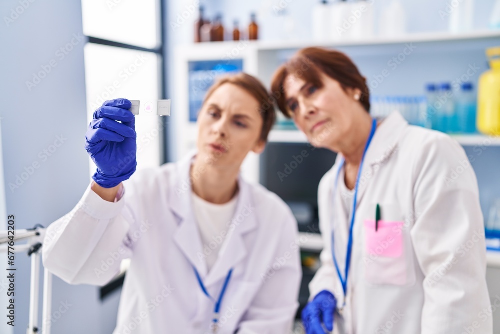 Two women scientist looking sample at laboratory Two women scientist looking sample at laboratory