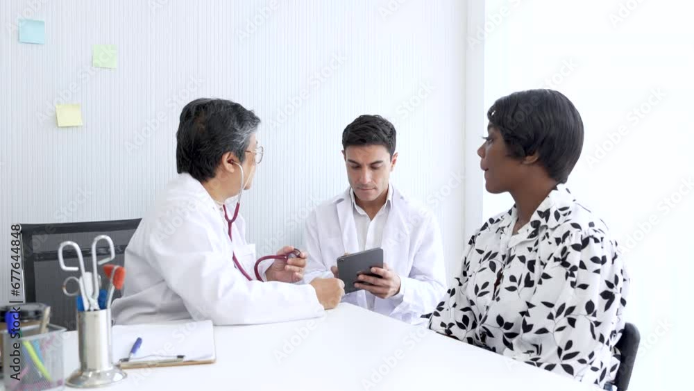 Professional elderly senior women and young man doctors giving a consulting to a mix African-American women. Healthy middle age women listening the doctor advice for annual health check up. Professional elderly senior women and young man doctors giving a consulting to a mix African-American women. Healthy middle age women listening the doctor advice for annual health check up.