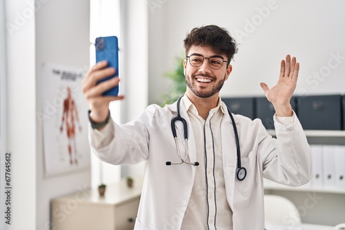 Hispanic man with beard working on online appointment celebrating achievement with happy smile and winner expression with raised hand