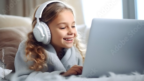 girl wearing headphones sits in front of a laptop and studies. Online classes for children