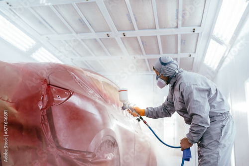 Schilderij op canvas A car service worker coats a car with varnish using compressor