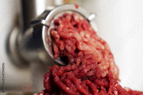 Fresh raw minced meat in the meat grinder, close-up