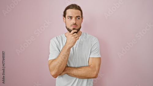 Young hispanic man standing with doubt expression over isolated pink background