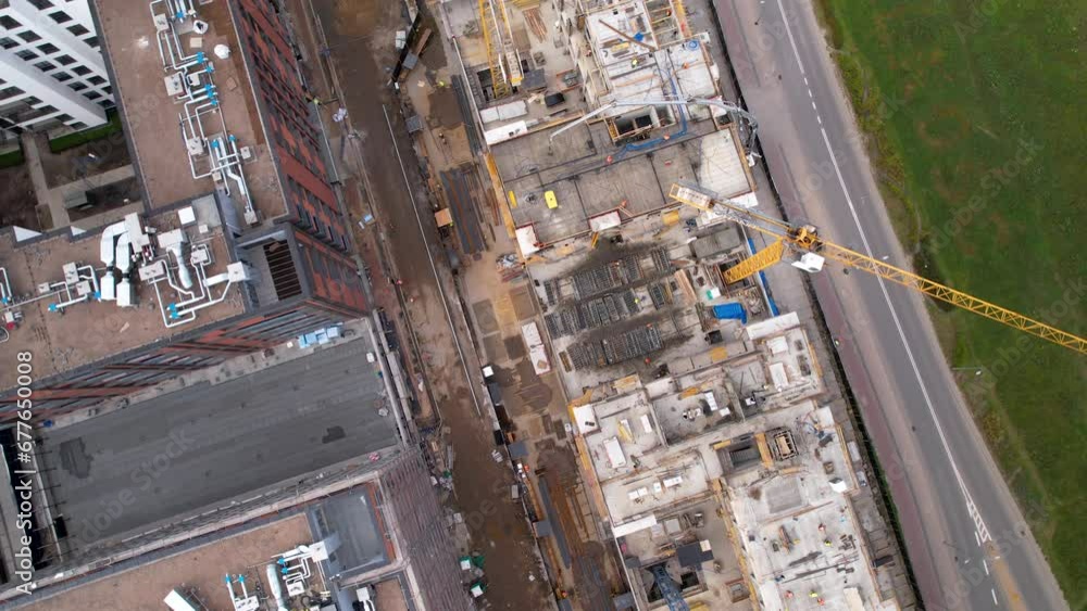 Drone top down rotating view above construction cranes at site building skyscraper Drone top down rotating view above construction cranes at site building skyscraper