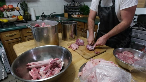 Trimming raw meat from pork skin preparing for processing after freshly butchered pig portioned into variety of cuts. photo