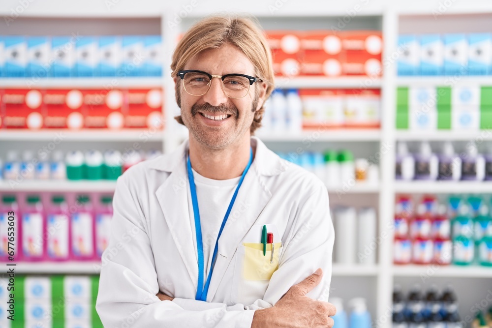 Caucasian man with mustache working at pharmacy drugstore happy face smiling with crossed arms looking at the camera. positive person. Caucasian man with mustache working at pharmacy drugstore happy face smiling with crossed arms looking at the camera. positive person.