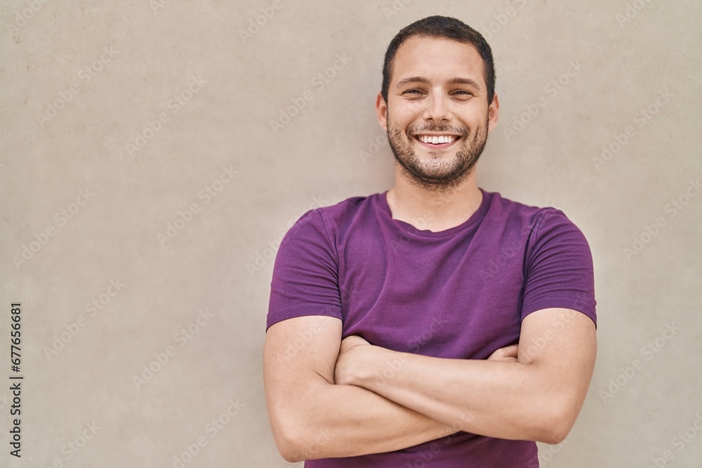 Young man smiling confident standing with arms crossed gesture over white isolated background Young man smiling confident standing with arms crossed gesture over white isolated background