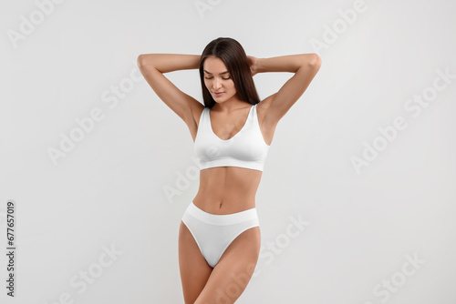 Young woman in stylish bikini on white background