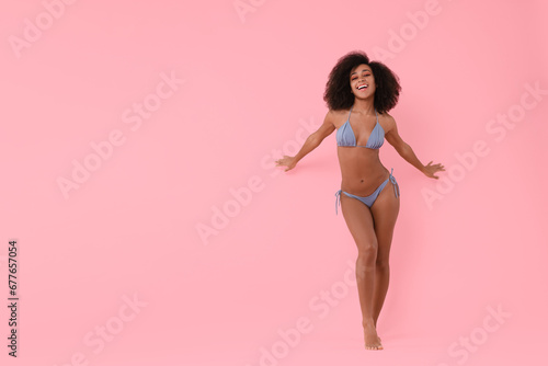 Beautiful woman in stylish bikini posing on pink background. Space for text