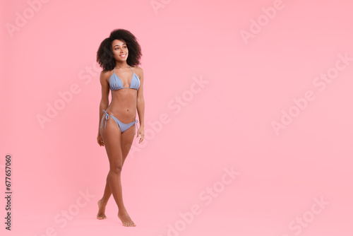 Beautiful woman in stylish bikini on pink background, space for text