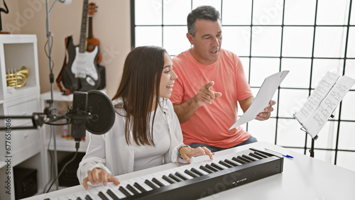 Foto Smiling man and woman musicians engrossed in their music studio lesson, harmoniz