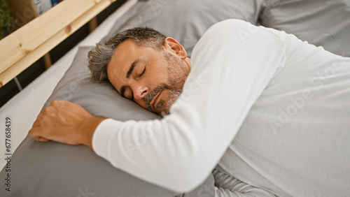 Young hispanic grey-haired man lying on bed sleeping at bedroom