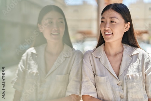 Chinese woman smiling confident looking to the side at street © Krakenimages.com