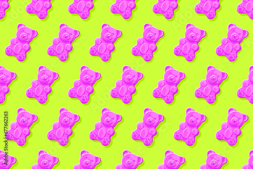 Pink gummy bears on bright green background. Seamless pattern. Texture for fabric, wallpaper, decorative print	