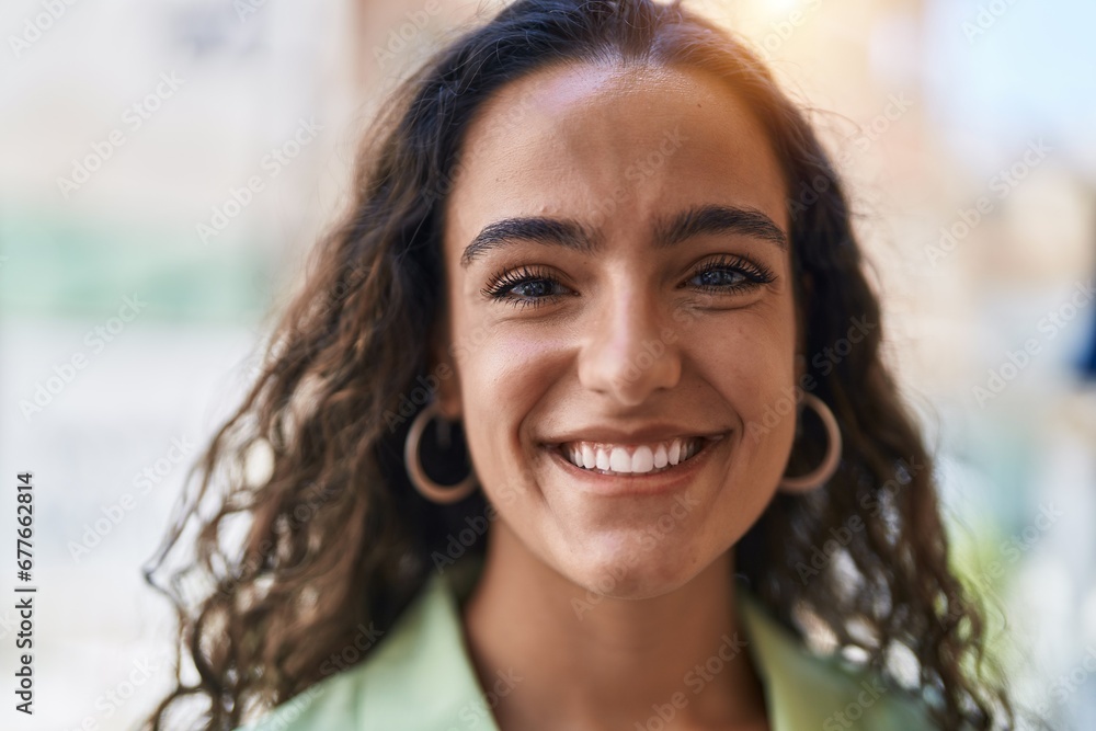 Fototapeta premium Young beautiful hispanic woman smiling confident standing at street