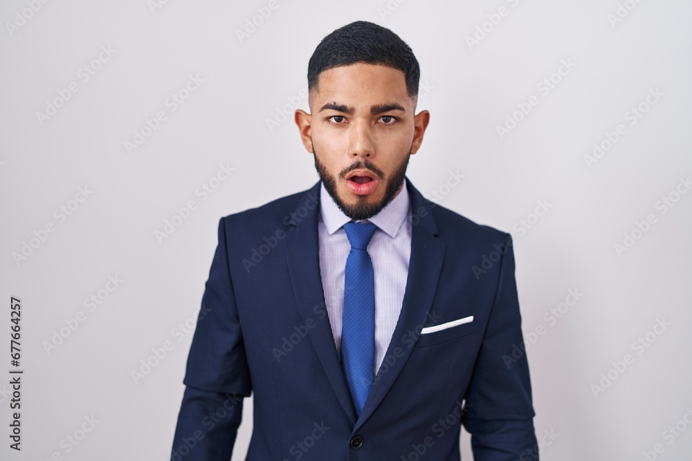 Young hispanic man wearing business suit and tie afraid and shocked with surprise and amazed expression, fear and excited face. Young hispanic man wearing business suit and tie afraid and shocked with surprise and amazed expression, fear and excited face.