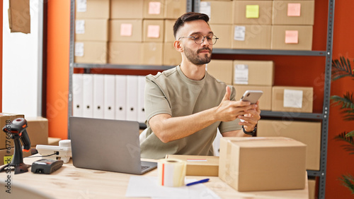 Young hispanic man ecommerce business worker scanning package at office