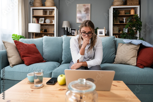 Εκτύπωση καμβά Young female doctor medical worker working from home sitting on sofa having video call with nervous sick patient listening and caring for people
