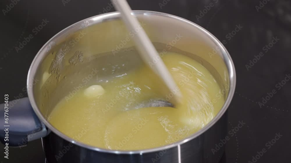 woman melts butter with sugar in saucepan on the stove for cooking Christmas gingerbread cookies woman melts butter with sugar in saucepan on the stove for cooking Christmas gingerbread cookies