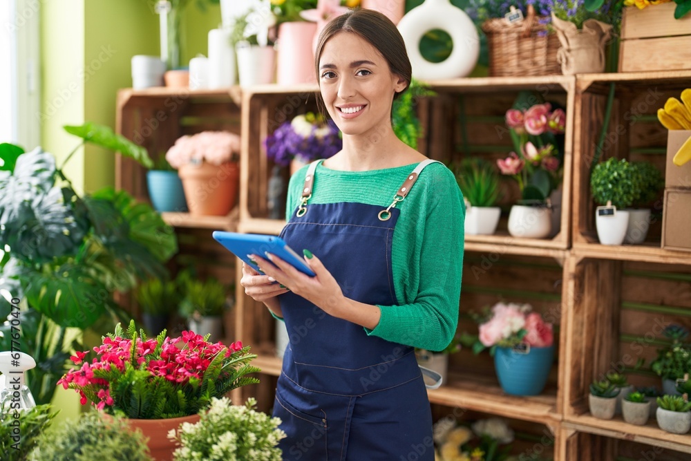 Young beautiful hispanic woman florist smiling confident using touchpad at flower shop Young beautiful hispanic woman florist smiling confident using touchpad at flower shop