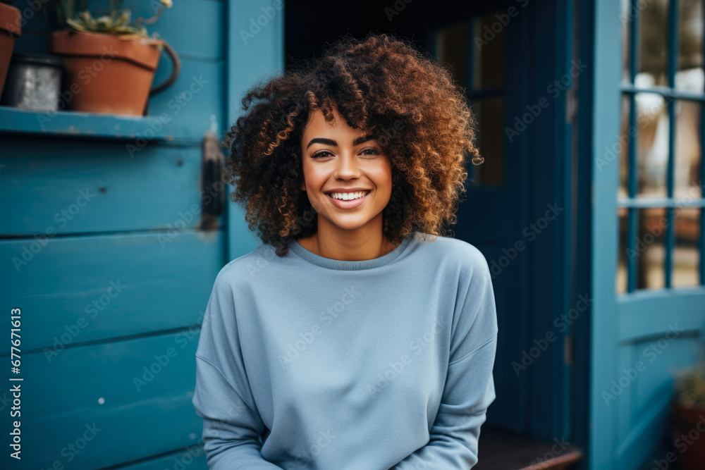 Fototapeta premium Urban Style: African American Woman in a Relaxed Pose in a Blue Sweater