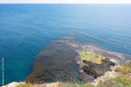 Cape Tarkhankut on the Crimean peninsula. The rocky coast of the Dzhangul Reserve in the Crimea. The Black Sea. Turquoise sea water. Rocks and grottoes of Cape Tarkhankut. photo