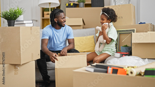 African american father and daughter unpacking teddy bear of cardboard box at new home © Krakenimages.com