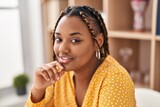 African american woman smiling confident sitting on table at home