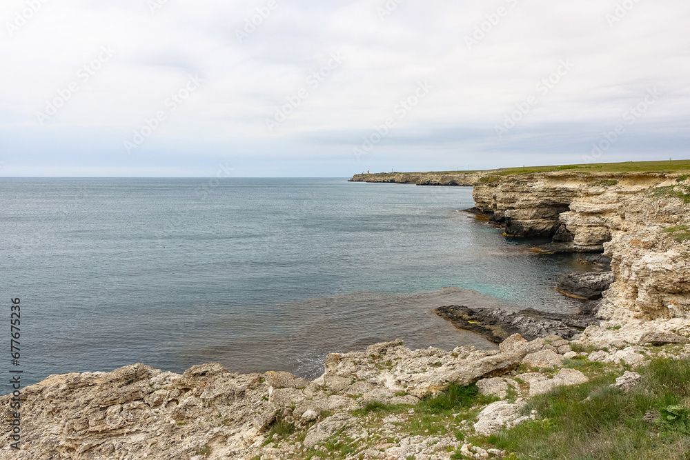 Cape Tarkhankut on the Crimean peninsula. The rocky coast of the Dzhangul Reserve in the Crimea. The Black Sea. Turquoise sea water. Rocks and grottoes of Cape Tarkhankut. Cape Tarkhankut on the Crimean peninsula. The rocky coast of the Dzhangul Reserve in the Crimea. The Black Sea. Turquoise sea water. Rocks and grottoes of Cape Tarkhankut.