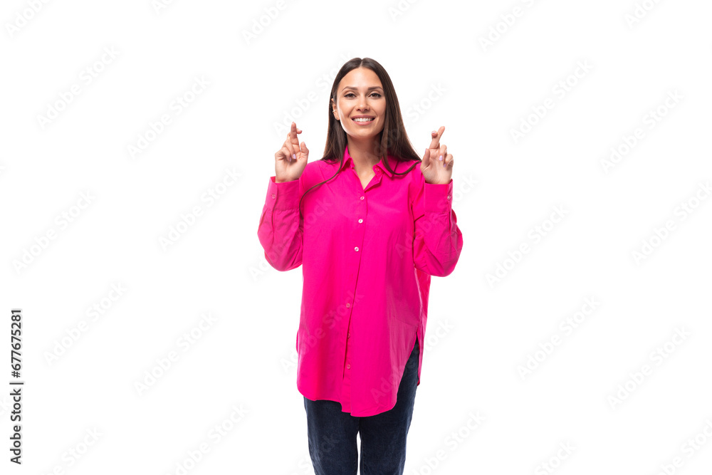 a slender caucasian woman with black straight hair is dressed in an oversized raspberry shirt with her fingers crossed a slender caucasian woman with black straight hair is dressed in an oversized raspberry shirt with her fingers crossed